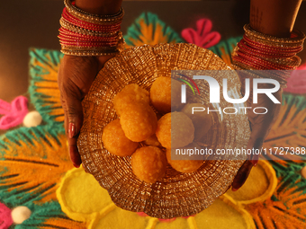 A Hindu devotee holds a bowl of laddus (a traditional Indian sweet) during the festival of Diwali at a Hindu temple in Toronto, Ontario, Can...