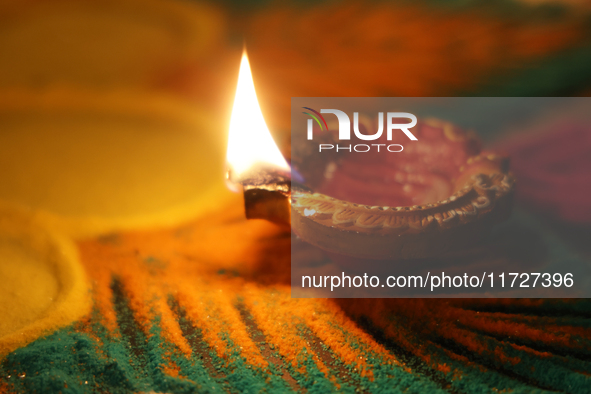 A diya (small clay lamp) sits by a rangoli design during the festival of Diwali at a Hindu temple in Toronto, Ontario, Canada, on October 31...