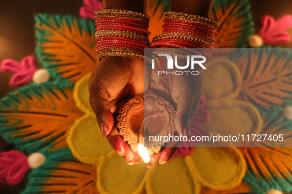 A Hindu devotee holds a diya (small clay lamp) during the festival of Diwali at a Hindu temple in Toronto, Ontario, Canada, on October 31, 2...