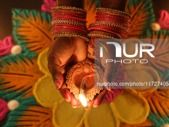 A Hindu devotee holds a diya (small clay lamp) during the festival of Diwali at a Hindu temple in Toronto, Ontario, Canada, on October 31, 2...