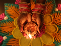 A Hindu devotee holds a diya (small clay lamp) during the festival of Diwali at a Hindu temple in Toronto, Ontario, Canada, on October 31, 2...