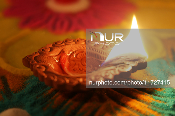 A diya (small clay lamp) sits by a rangoli design during the festival of Diwali at a Hindu temple in Toronto, Ontario, Canada, on October 31...