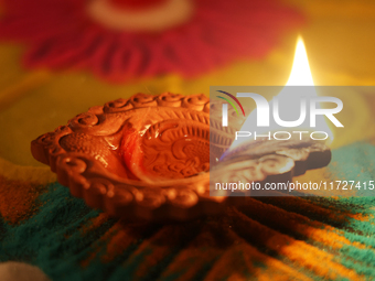 A diya (small clay lamp) sits by a rangoli design during the festival of Diwali at a Hindu temple in Toronto, Ontario, Canada, on October 31...