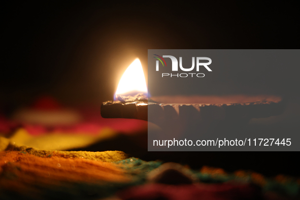 A diya (small clay lamp) sits by a rangoli design during the festival of Diwali at a Hindu temple in Toronto, Ontario, Canada, on October 31...