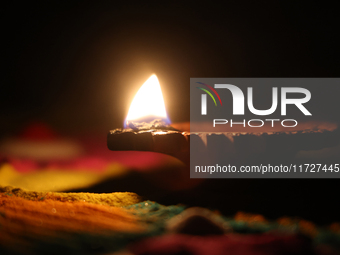 A diya (small clay lamp) sits by a rangoli design during the festival of Diwali at a Hindu temple in Toronto, Ontario, Canada, on October 31...