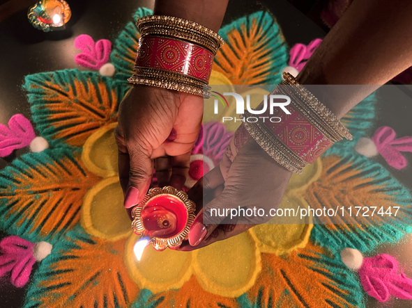 A Hindu devotee holds a diya (small clay lamp) during the festival of Diwali at a Hindu temple in Toronto, Ontario, Canada, on October 31, 2...