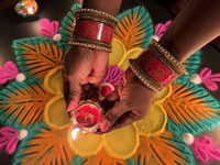 A Hindu devotee holds a diya (small clay lamp) during the festival of Diwali at a Hindu temple in Toronto, Ontario, Canada, on October 31, 2...