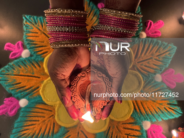 A Hindu devotee holds a diya (small clay lamp) during the festival of Diwali at a Hindu temple in Toronto, Ontario, Canada, on October 31, 2...