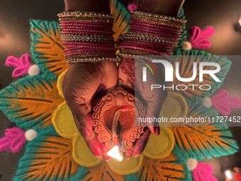 A Hindu devotee holds a diya (small clay lamp) during the festival of Diwali at a Hindu temple in Toronto, Ontario, Canada, on October 31, 2...