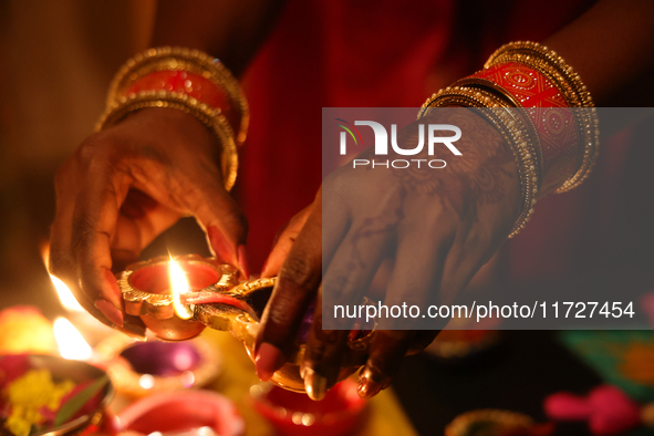 A Hindu devotee lights diyas (small clay lamps) during the festival of Diwali at a Hindu temple in Toronto, Ontario, Canada, on October 31,...