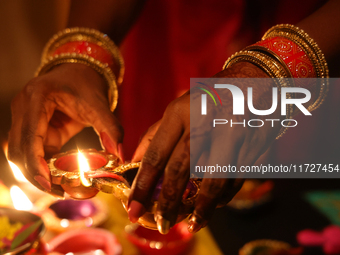 A Hindu devotee lights diyas (small clay lamps) during the festival of Diwali at a Hindu temple in Toronto, Ontario, Canada, on October 31,...