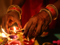 A Hindu devotee lights diyas (small clay lamps) during the festival of Diwali at a Hindu temple in Toronto, Ontario, Canada, on October 31,...