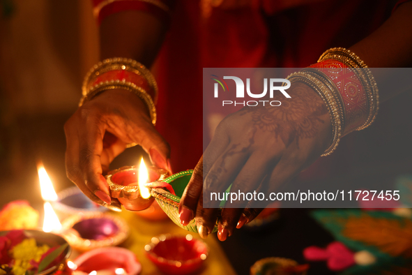 A Hindu devotee lights diyas (small clay lamps) during the festival of Diwali at a Hindu temple in Toronto, Ontario, Canada, on October 31,...