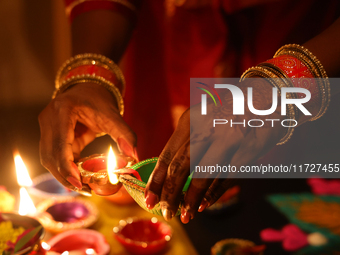 A Hindu devotee lights diyas (small clay lamps) during the festival of Diwali at a Hindu temple in Toronto, Ontario, Canada, on October 31,...