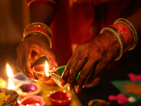 A Hindu devotee lights diyas (small clay lamps) during the festival of Diwali at a Hindu temple in Toronto, Ontario, Canada, on October 31,...