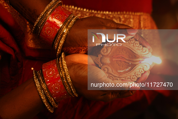 A Hindu devotee holds a diya (small clay lamp) during the festival of Diwali at a Hindu temple in Toronto, Ontario, Canada, on October 31, 2...