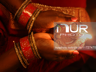 A Hindu devotee holds a diya (small clay lamp) during the festival of Diwali at a Hindu temple in Toronto, Ontario, Canada, on October 31, 2...