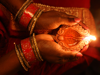 A Hindu devotee holds a diya (small clay lamp) during the festival of Diwali at a Hindu temple in Toronto, Ontario, Canada, on October 31, 2...