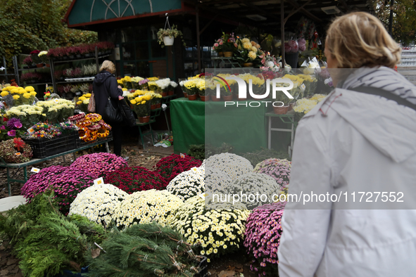 A stand with flowers and candles is next to the Rakowicki Cemetery during preparations for All Saints' Day in Krakow, Poland, on October 30,...