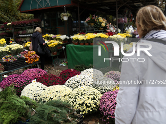 A stand with flowers and candles is next to the Rakowicki Cemetery during preparations for All Saints' Day in Krakow, Poland, on October 30,...