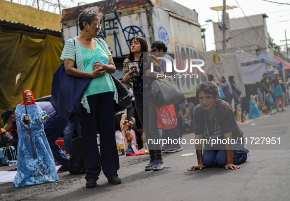 A devotee visits the Altar of Santa Muerte on his knees on Alfareria Street in the Tepito neighborhood to show devotion and give thanks for...