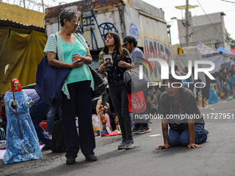 A devotee visits the Altar of Santa Muerte on his knees on Alfareria Street in the Tepito neighborhood to show devotion and give thanks for...