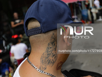 A tattoo of Santa Muerte is on the neck of a devotee attending the Altar of Santa Muerte on Alfareria Street in the Tepito neighborhood to s...