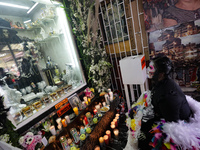 A devotee disguised as a catrina prays in front of Santa Muerte's altar in the Tepito neighborhood to show devotion and give thanks for favo...