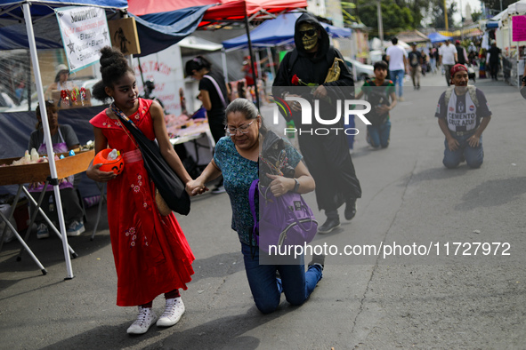 A devotee visits the Altar of Santa Muerte on his knees on Alfareria Street in the Tepito neighborhood to show devotion and give thanks for...