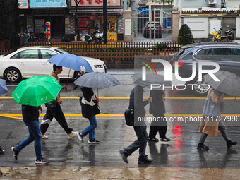 Pedestrians hold umbrellas as they walk on a street in Shanghai, China, on November 1, 2024. (