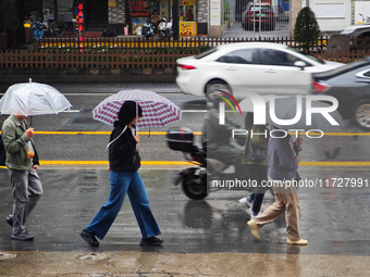 Pedestrians hold umbrellas as they walk on a street in Shanghai, China, on November 1, 2024. (