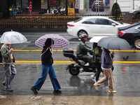 Pedestrians hold umbrellas as they walk on a street in Shanghai, China, on November 1, 2024. (