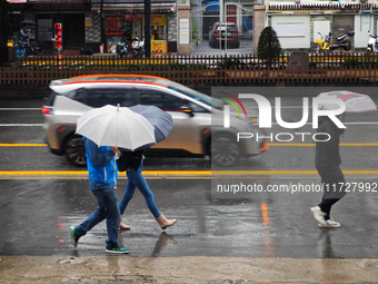 Pedestrians hold umbrellas as they walk on a street in Shanghai, China, on November 1, 2024. (