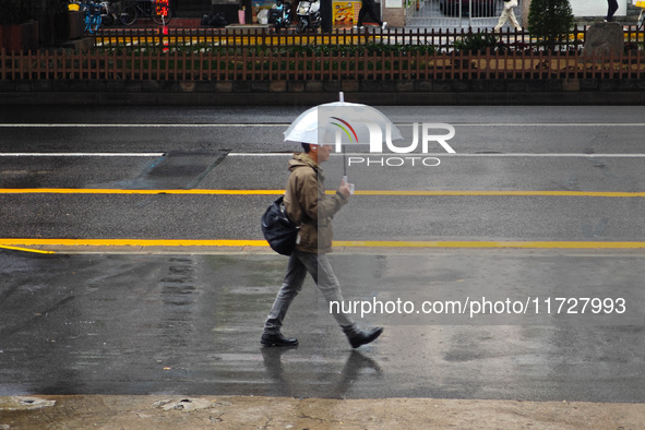 Pedestrians hold umbrellas as they walk on a street in Shanghai, China, on November 1, 2024. 