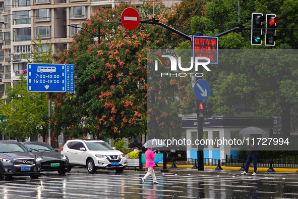 Pedestrians hold umbrellas as they walk on a street in Shanghai, China, on November 1, 2024. 