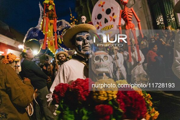 A boy with his face painted as a skull takes part in a parade known locally as a 'comparsa,' walking the main streets of Oaxaca City as part...