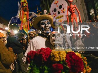 A boy with his face painted as a skull takes part in a parade known locally as a 'comparsa,' walking the main streets of Oaxaca City as part...