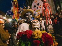 A boy with his face painted as a skull takes part in a parade known locally as a 'comparsa,' walking the main streets of Oaxaca City as part...