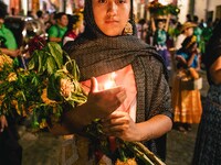 A woman wearing a traditional Mexican dress takes part in a parade known locally as a 'comparsa,' walking the main streets of Oaxaca City as...