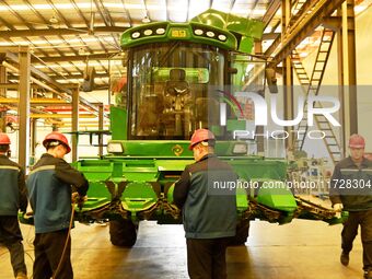 Construction workers assemble agricultural machinery at Jiufang Taihe International Heavy Industries (Qingdao) Co., LTD., Hongshiya Street,...