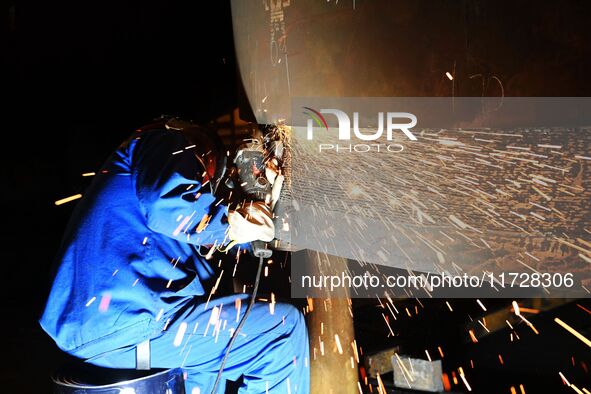 A construction worker builds petrochemical equipment parts at Lanshi Heavy Machinery Co., LTD., Hongshiya Street, in Qingdao, China, on Octo...