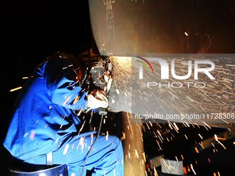 A construction worker builds petrochemical equipment parts at Lanshi Heavy Machinery Co., LTD., Hongshiya Street, in Qingdao, China, on Octo...