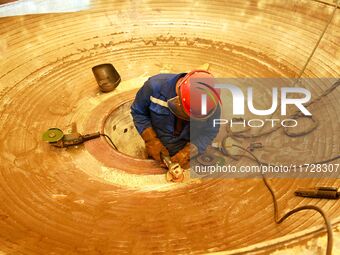 A construction worker builds petrochemical equipment parts at Lanshi Heavy Machinery Co., LTD., Hongshiya Street, in Qingdao, China, on Octo...