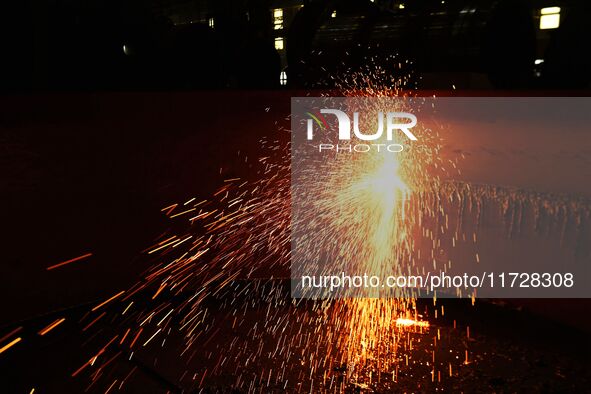 A construction worker builds petrochemical equipment parts at Lanshi Heavy Machinery Co., LTD., Hongshiya Street, in Qingdao, China, on Octo...