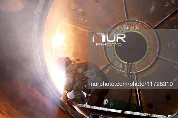 A construction worker builds petrochemical equipment parts at Lanshi Heavy Machinery Co., LTD., Hongshiya Street, in Qingdao, China, on Octo...