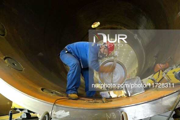 A construction worker builds petrochemical equipment parts at Lanshi Heavy Machinery Co., LTD., Hongshiya Street, in Qingdao, China, on Octo...