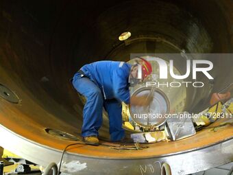 A construction worker builds petrochemical equipment parts at Lanshi Heavy Machinery Co., LTD., Hongshiya Street, in Qingdao, China, on Octo...