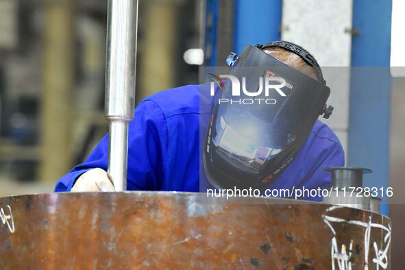 A construction worker builds petrochemical equipment parts at Lanshi Heavy Machinery Co., LTD., Hongshiya Street, in Qingdao, China, on Octo...