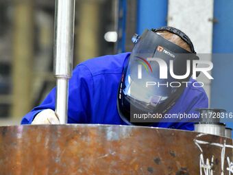 A construction worker builds petrochemical equipment parts at Lanshi Heavy Machinery Co., LTD., Hongshiya Street, in Qingdao, China, on Octo...