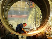 A construction worker builds petrochemical equipment parts at Lanshi Heavy Machinery Co., LTD., Hongshiya Street, in Qingdao, China, on Octo...